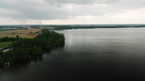 Reelfoot-lake-state-park,-showing-expansive-water-bordered-by-lush-forests-and-farmland,-aerial-view