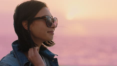 retrato de una hermosa mujer asiática sonriendo disfrutando de un estilo de vida despreocupado explorando la libertad en vacaciones pareciendo feliz con el viento soplando el cabello usando gafas de sol