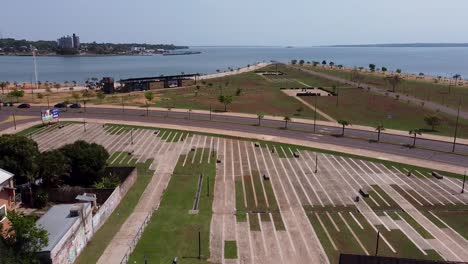 drone pan up over empty skate park to reveal surrounding park and blue ocean and sky