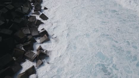 Flying-Low-Over-Black-Rocks-With-Small-Waves-And-Foam,-Puerto-De-La-Cruz,-Spain