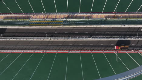 aerial top-down sideways shot of traffic on cross bay link bridge in hong kong during golden hour