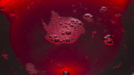 red wine foamy texture closeup. bubbled liquid surface frothing moving top view