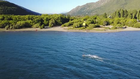 pan left slow motion of a person kitesurfing at puelo lake, mountains in background, patagonia argentina
