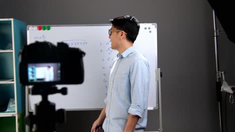 young male teacher recording video at home