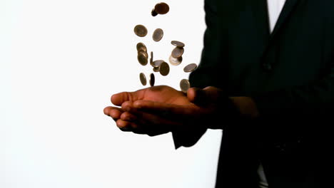 businessman catching falling coins in hands