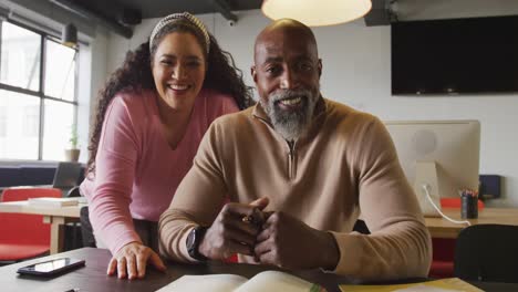 portrait of happy diverse business people looking at camera at office