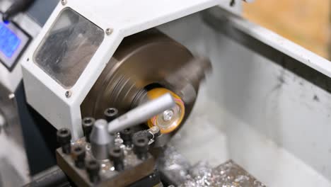 close-up: a metal component is precisely machined on a lathe, creating shavings. this industrial process highlights weapon modification at a drone workshop for modern warfare