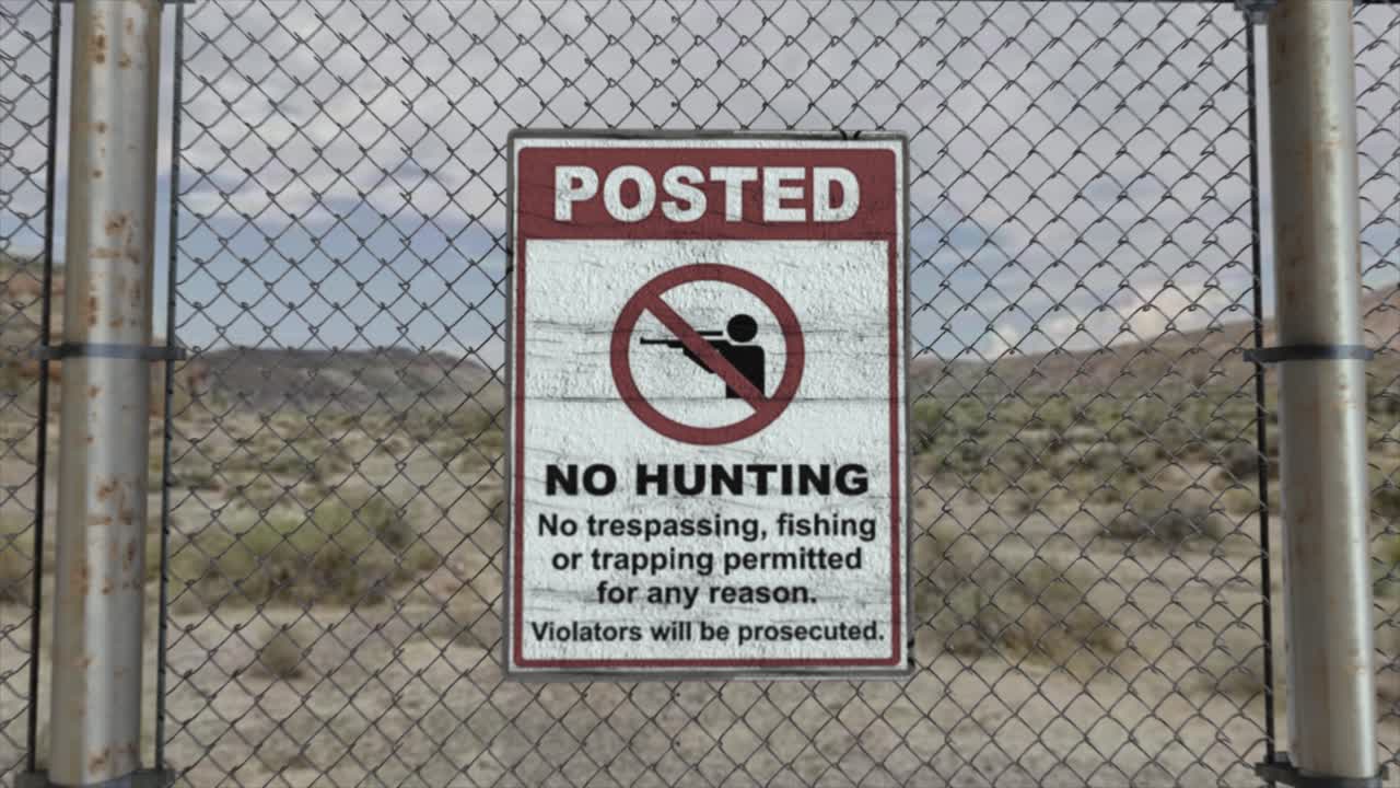 높은 품질의 3d cgi 렌더링과 부드러운 dolly-in 은 사막 장면에서 높은 보안 설치에서 체인링크 울타리, 사냥 금지, 침입 금지 표지판과 함께