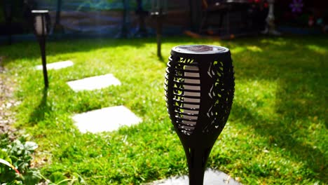 iluminación de antorcha moderna y elegante con energía solar en el césped del jardín iluminado por el sol