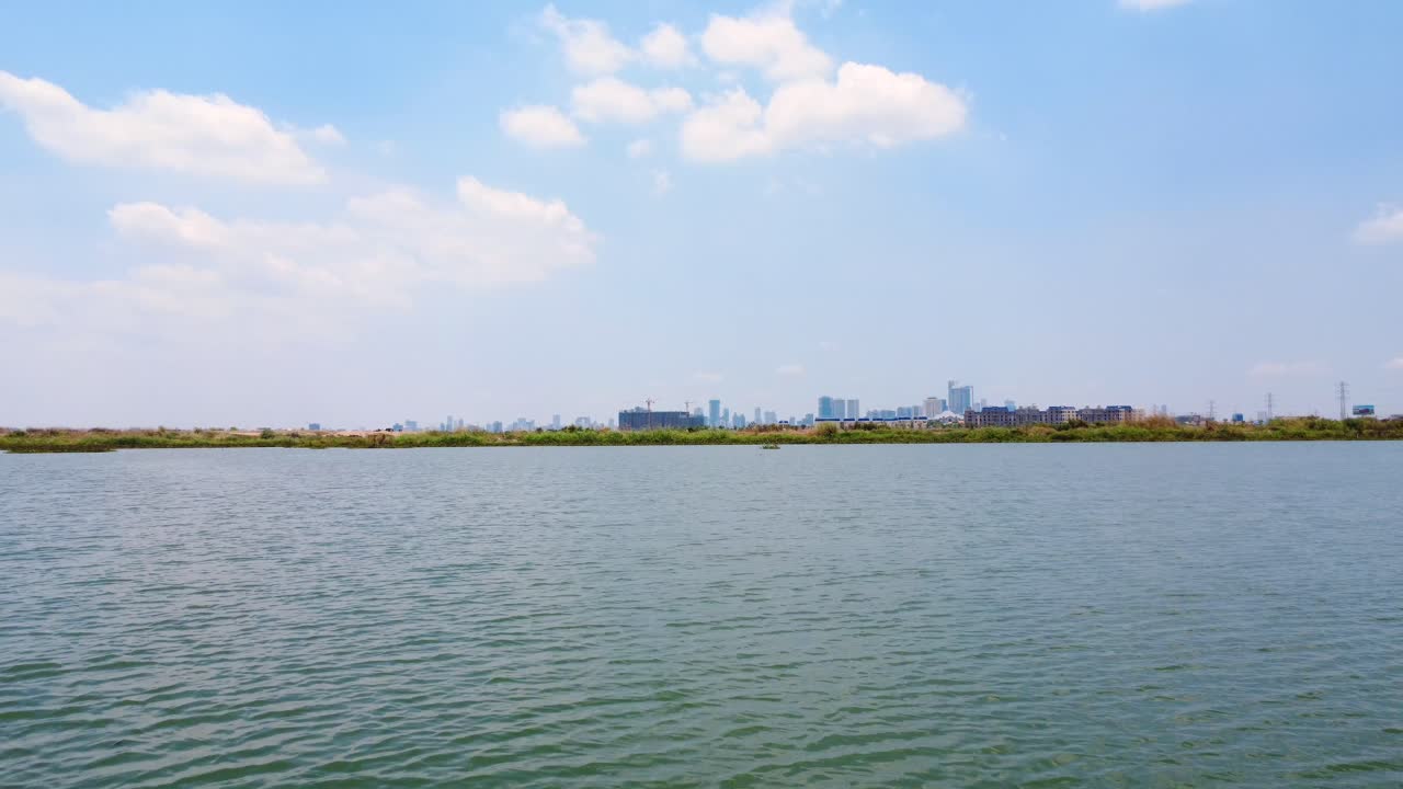 By Boeung Tamok’s gentle shore, Phnom Penh rises, proud once more