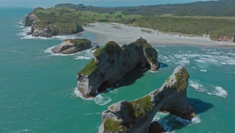 impresionante vista aérea de drones de un paisaje escarpado y rocoso en la playa de wharariki, cabo adiós, isla sur de nueva zelanda aotearoa