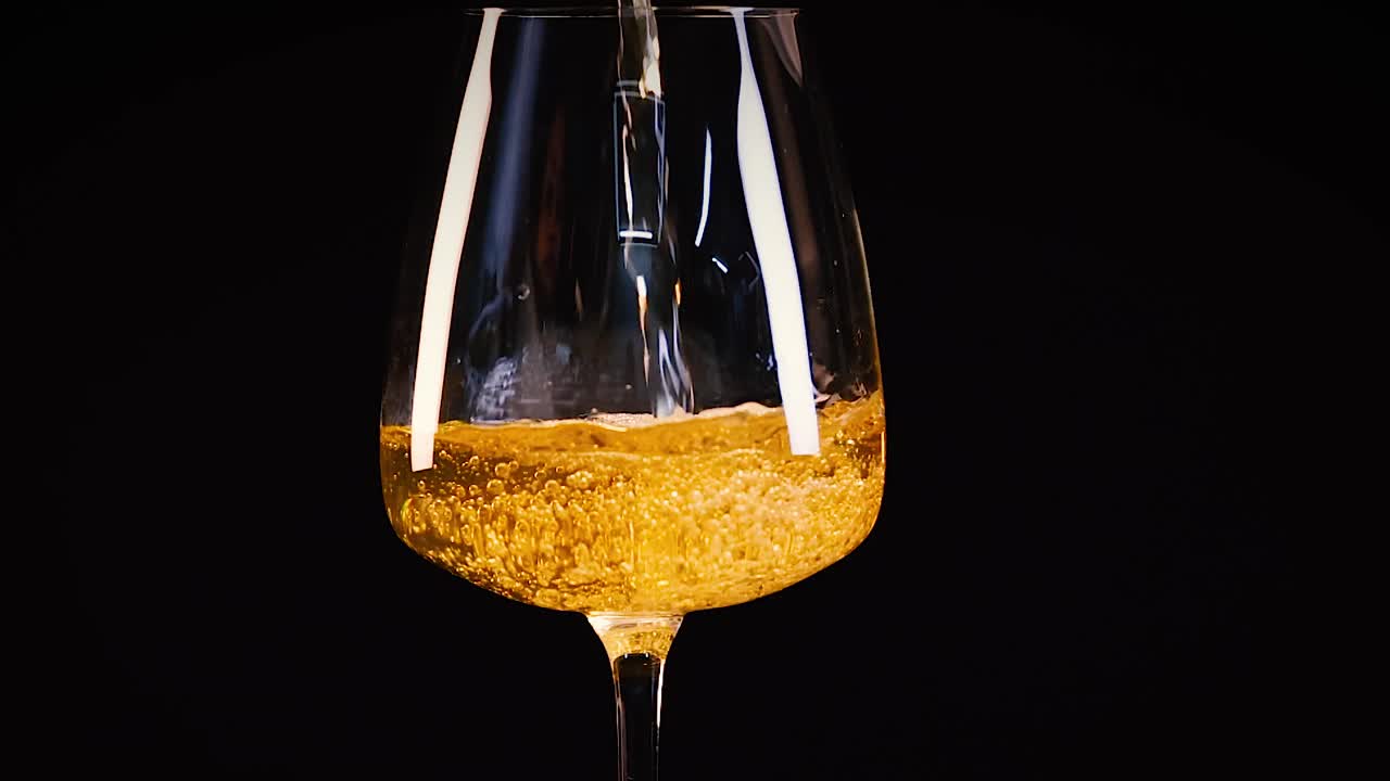 Un flusso di vino bianco dorato riempie un calice di cristallo su uno sfondo scuro ed elegante