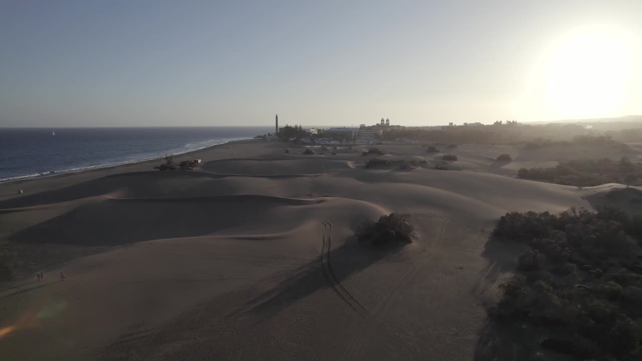 gente caminando en las dunas de arena dorada de maspalomas, impresionante puesta de sol, gran canaria