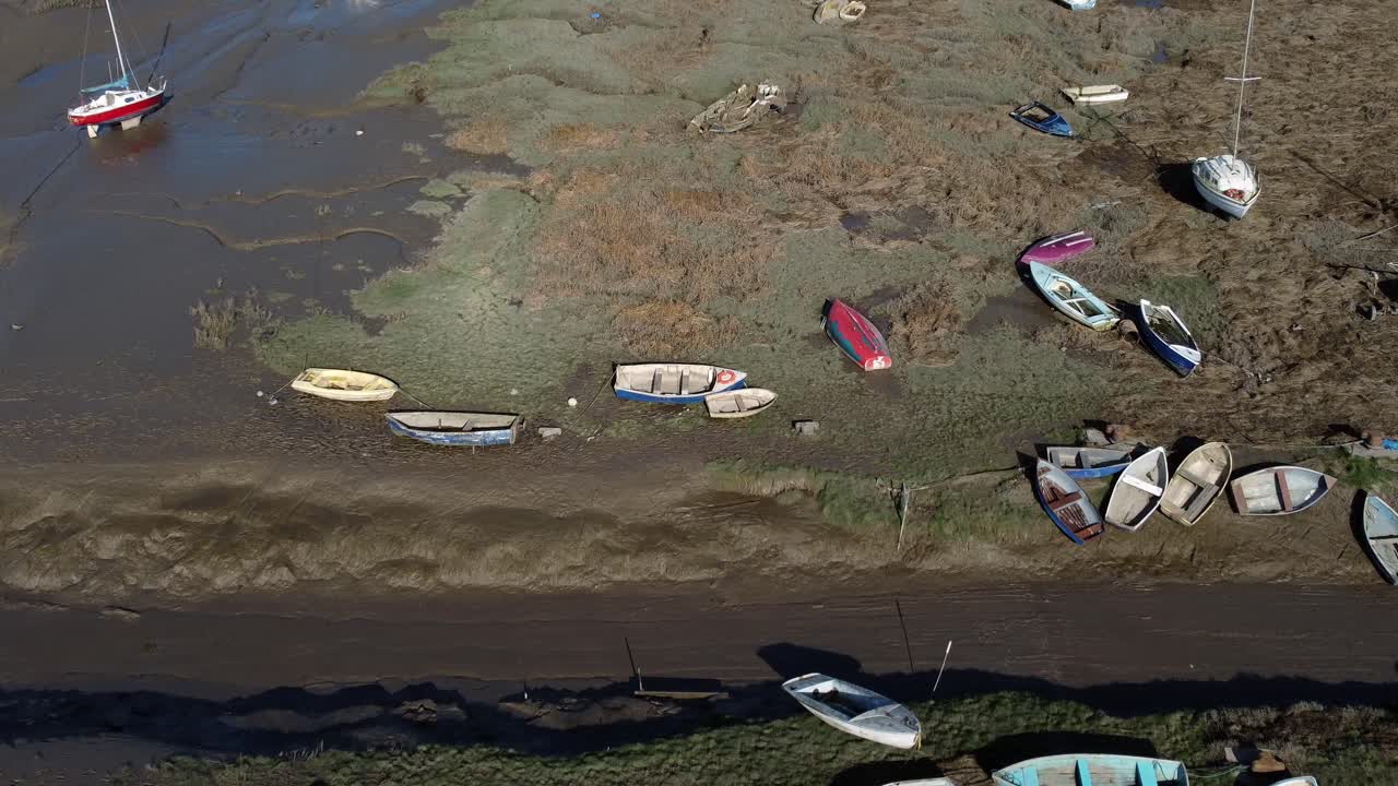 varios barcos de pesca amarrados astillero naufragio en pantano barro marea baja vista aérea de la costa empujar en inclinación hacia abajo