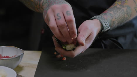 closeup shot of a chef preparing sushi hand rolls