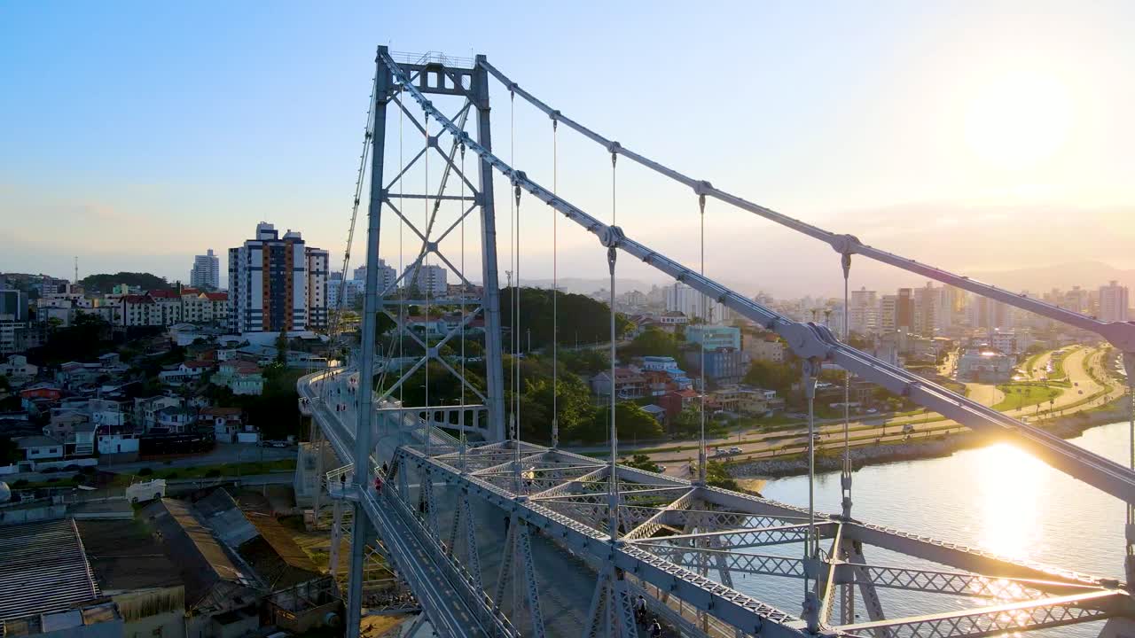 현수교 hercilio luz의 공중 드론 장면은 일몰 시 배경의 구조와 도시를 드러냅니다.