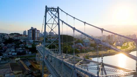 escena aérea de drones del puente colgante hercilio luz que revela su estructura y la ciudad en el fondo al atardecer