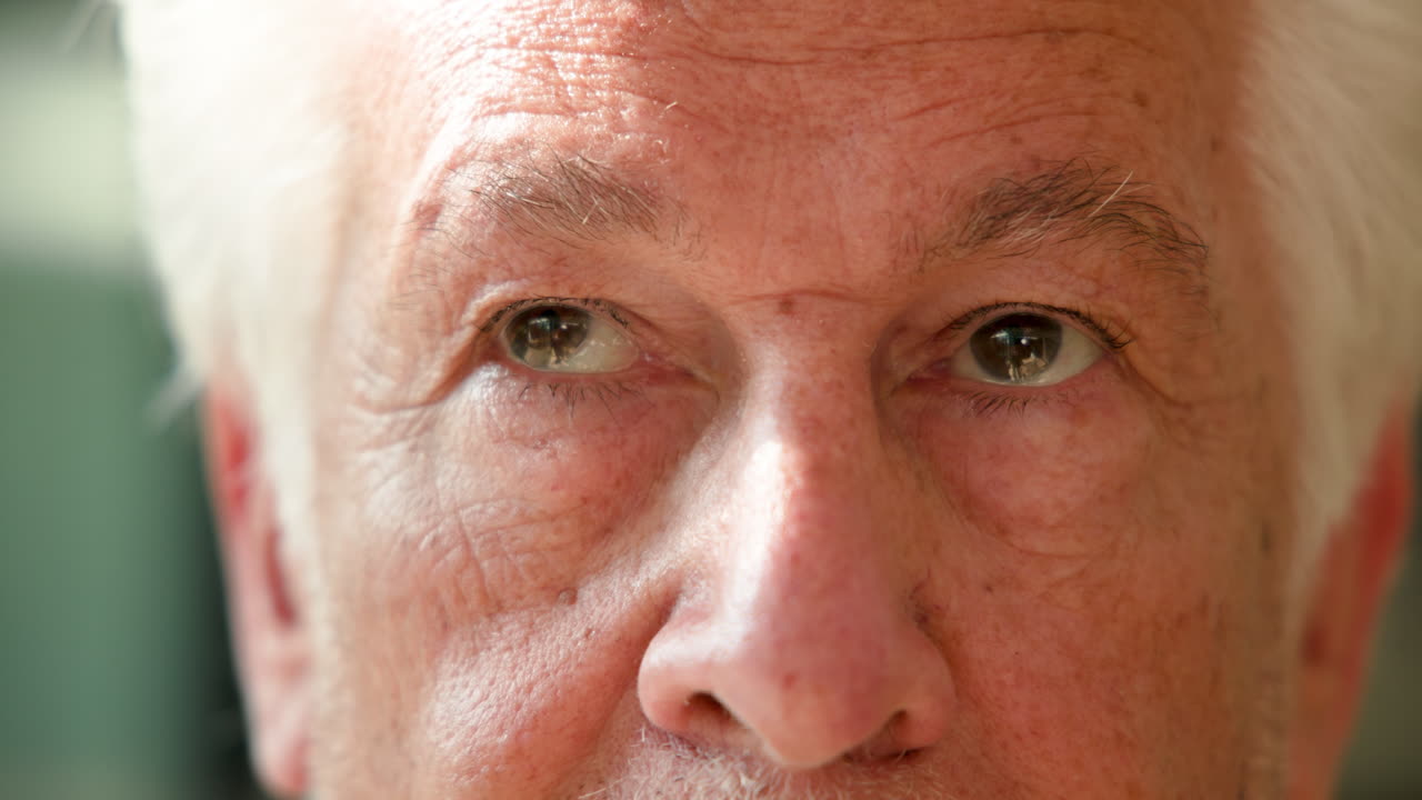 Elderly man's eyes showing warmth and wisdom in thoughtful expression, on deck