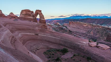 panning timelapse from day to sunset with unique rock formations at delicate arch in arches national park