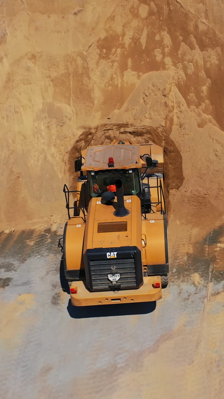 Aerial view of construction place. Industrial excavator working on construction site, aerial drone view Vertical video