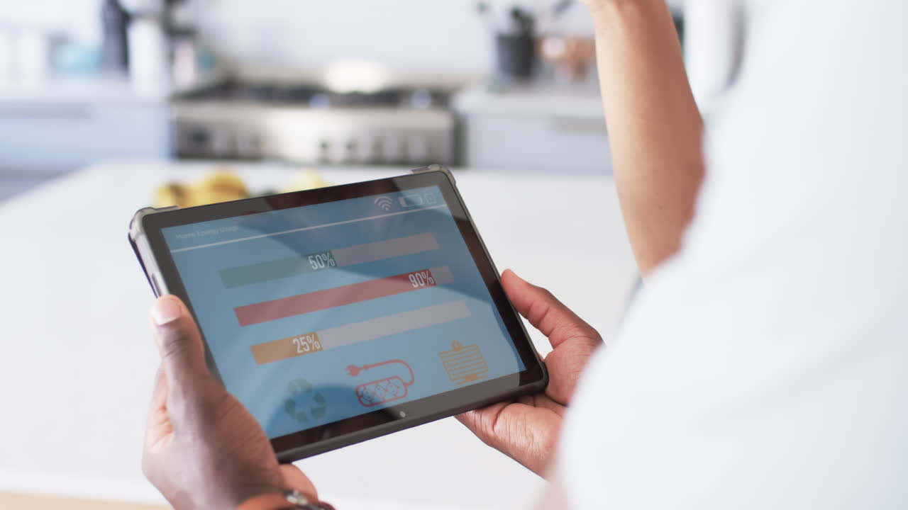 una pareja afroamericana está revisando el uso de energía de la aplicación de hogar inteligente en una tableta