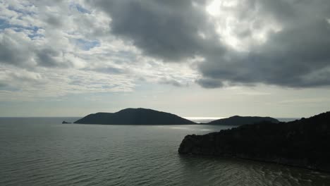 Imágenes-Aéreas-Hacia-La-Derecha-De-Estas-Islas-Súper-Encantadoras-En-El-Horizonte-Y-Una-Montaña-De-Piedra-Caliza-En-Primer-Plano