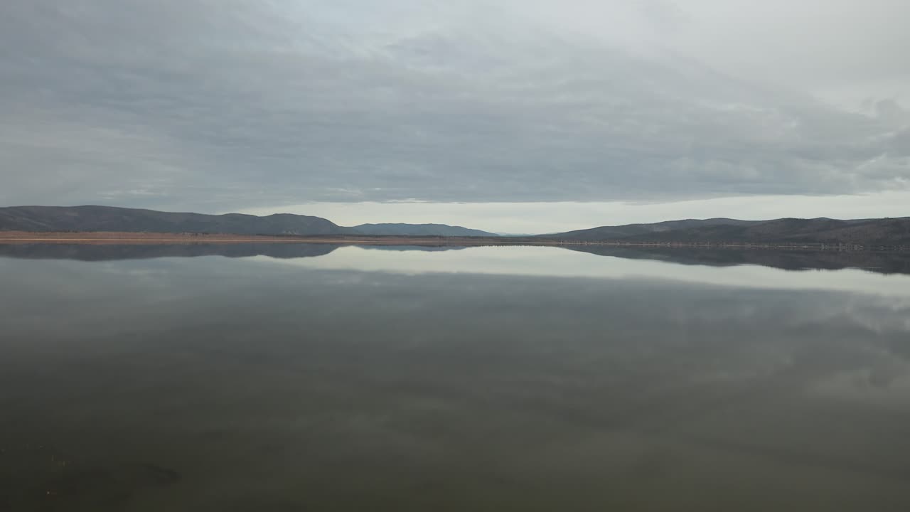 산들은 일몰 때 알래스카 호수에 반사됩니다.