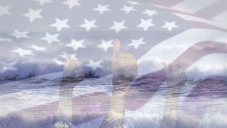 digital composition of waving us flag over hands showing thumbs up against waves in the sea