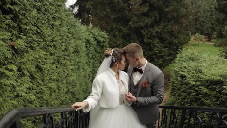 Newlyweds,-caucasian-groom-with-bride-stay-on-stairs-in-park,-wedding-couple,-man-and-woman-in-love