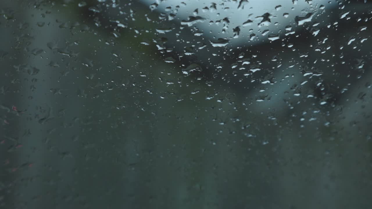 Rain Drops In Front Of A Wind Shield Of A Car On A Rainy Day. - close up shot