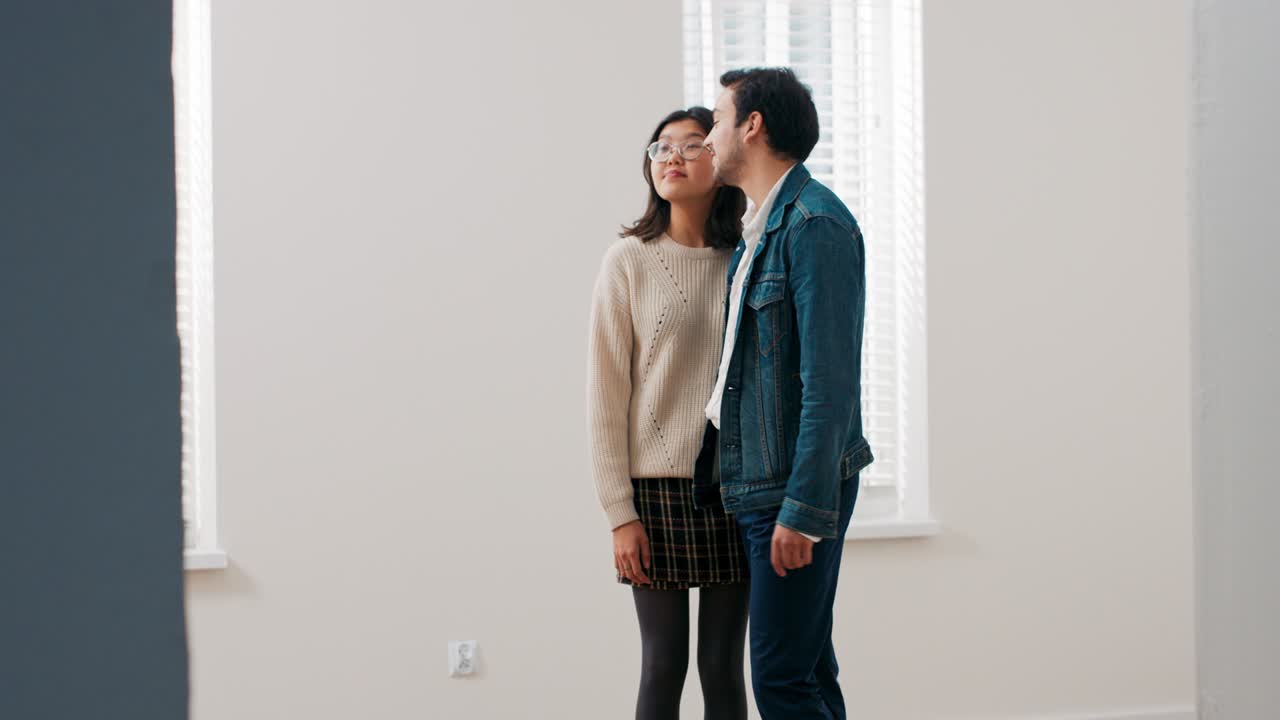 젊은 부부는 빈 아파트에 서서 서로 포옹하고, 움직임을 즐기고, 웃고, 사랑에 빠지고, 행복하고, 이야기하고, 집의 장식, 장식에 대해 생각합니다.