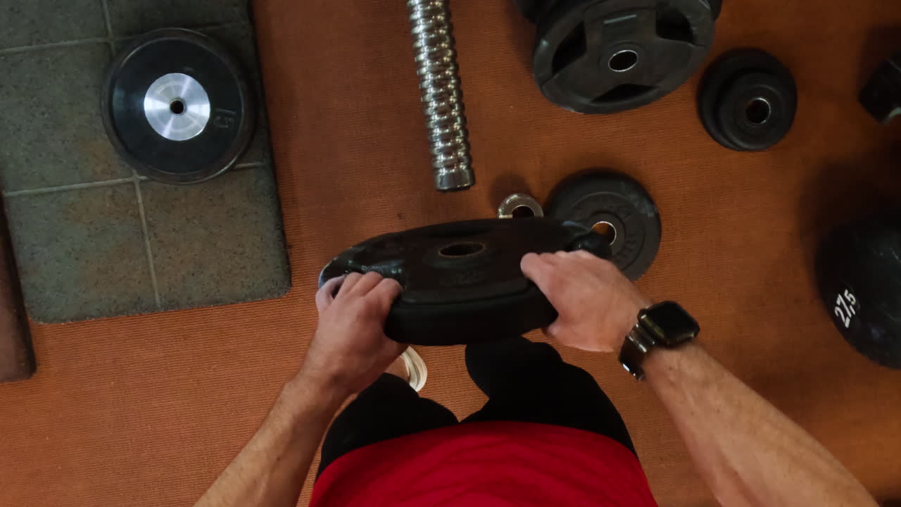 Person preparing weights in a gym, first-person view