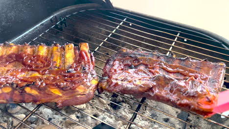 grilling and basting bbq pork ribs with brush