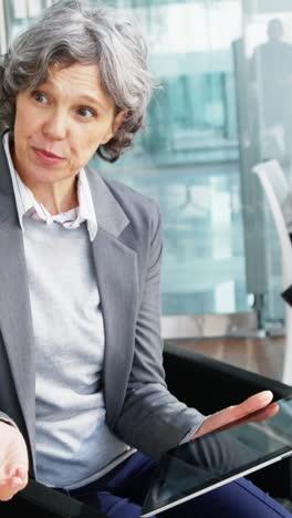 businesswoman discussing over digital tablet with colleague