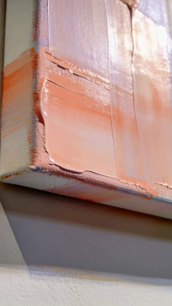 Vertical video: Tilting camera revealing canvas edge in gallery to show impasto sheen, copy space