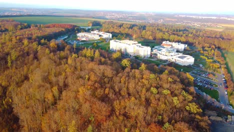 scenic aerial trucking pan right high above wellness facility in autumn, czech republic, surrounded by colorful fall foliage and nature