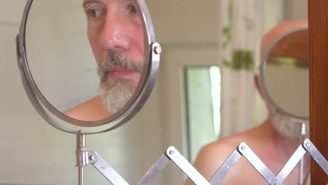 man looking at himself in a bathroom mirror