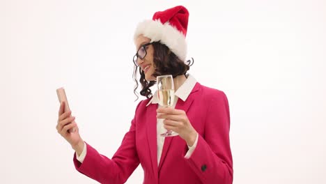 woman in santa hat with smartphone and champagne