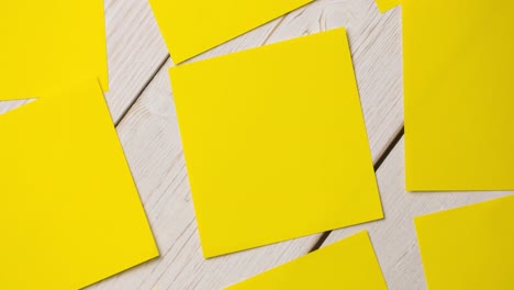 Animation-of-multiple-yellow-cards-lying-on-wooden-table