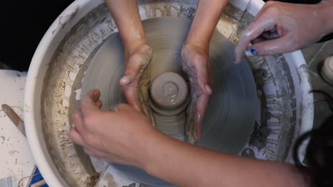 young woman artist making clay bowl on pottery wheel