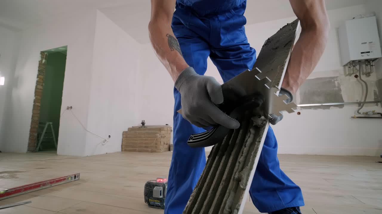 Installing ceramic floor tiles - measuring and cutting the pieces. Construction, renovation, repair apartment. Cuts tile. Tile cutting