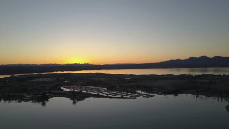 aerial view sunset over lake town with mountains 4k