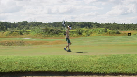 vista lejana de una mujer caucásica practicando golf en el campo de golf.