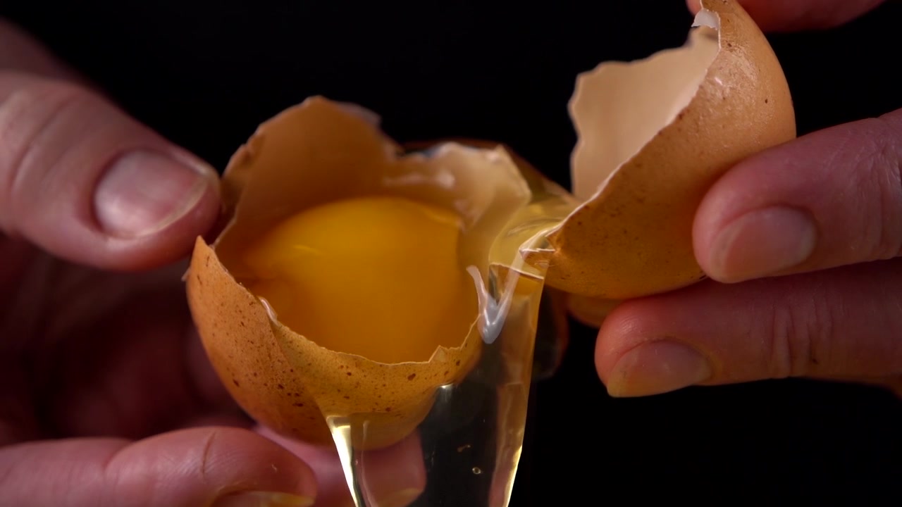 The cook reveals a broken raw egg.