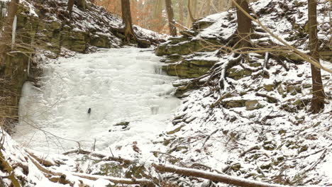 Gefrorener-Wasserfall-Und-Waldfluss-In-Kanadischen-Wäldern,-Ansicht-Nach-Links