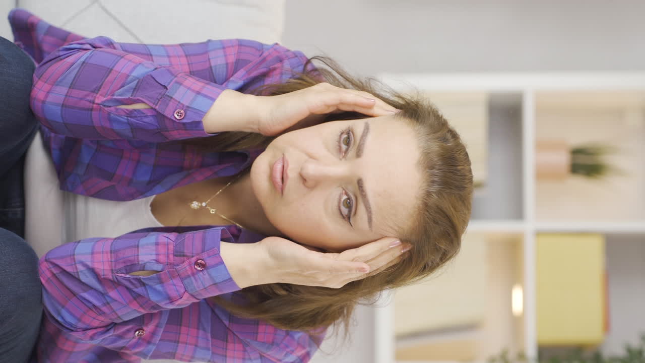 두통을  ⁇ 고 있는 여성의 수직 비디오.