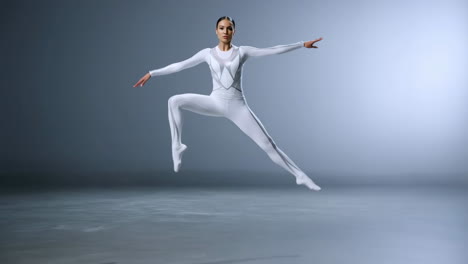 graceful dancer in white jumpsuit performing a dynamic leap