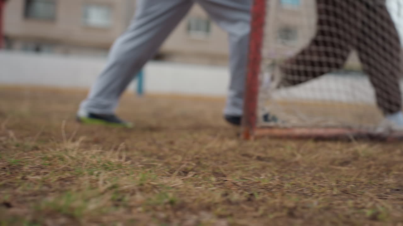 Atletas aficionados estiran en terrenos accidentados, practican deportes al aire libre con movimientos enérgicos y en un entorno desgastado; atletas en zapatillas participan activamente en terrenos irregulares durante una sesión de entrenamiento al aire libre.