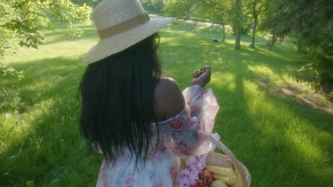 Black-Woman-walking-toward-park-in-dress-with-basket-close-up