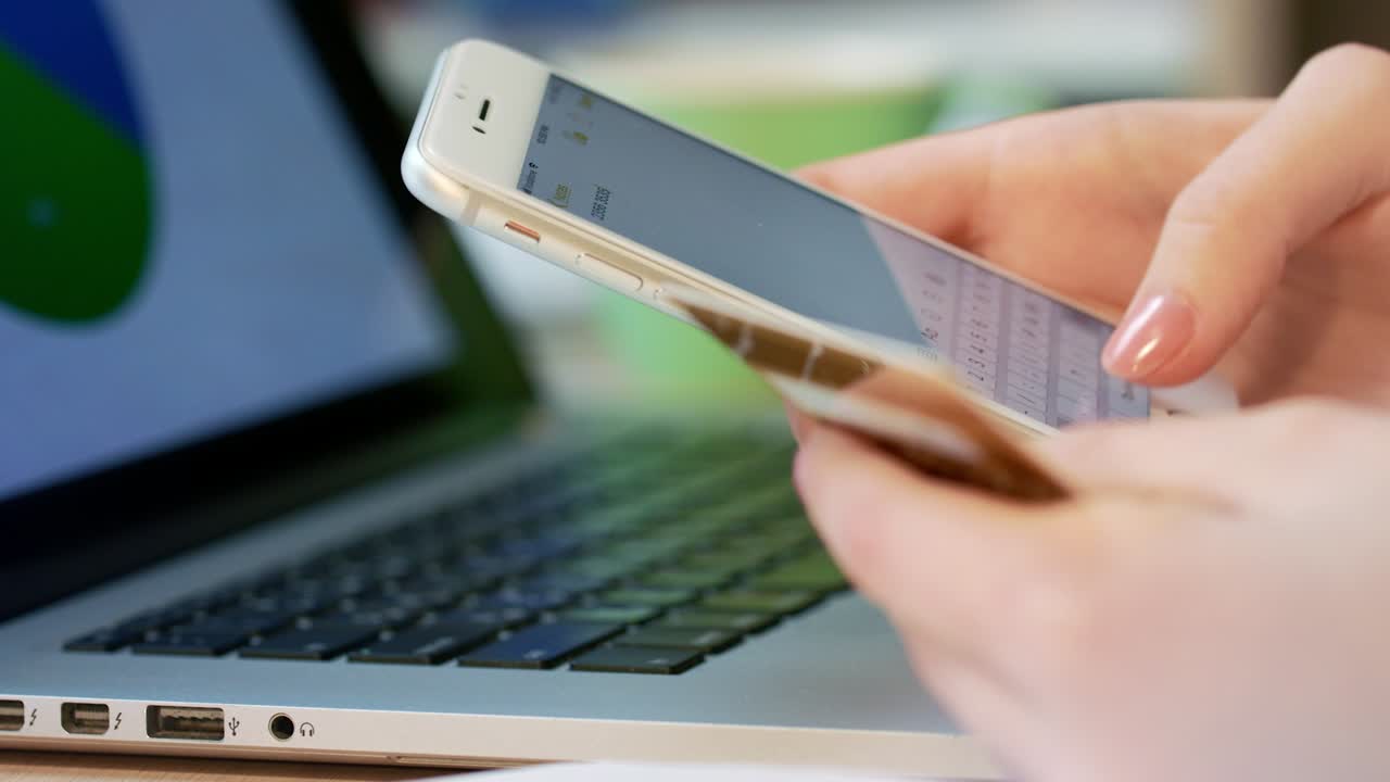 모바일  ⁇ 킹 서비스. 여성 손이 휴대 전화로 신용 카드 번호를 입력합니다.